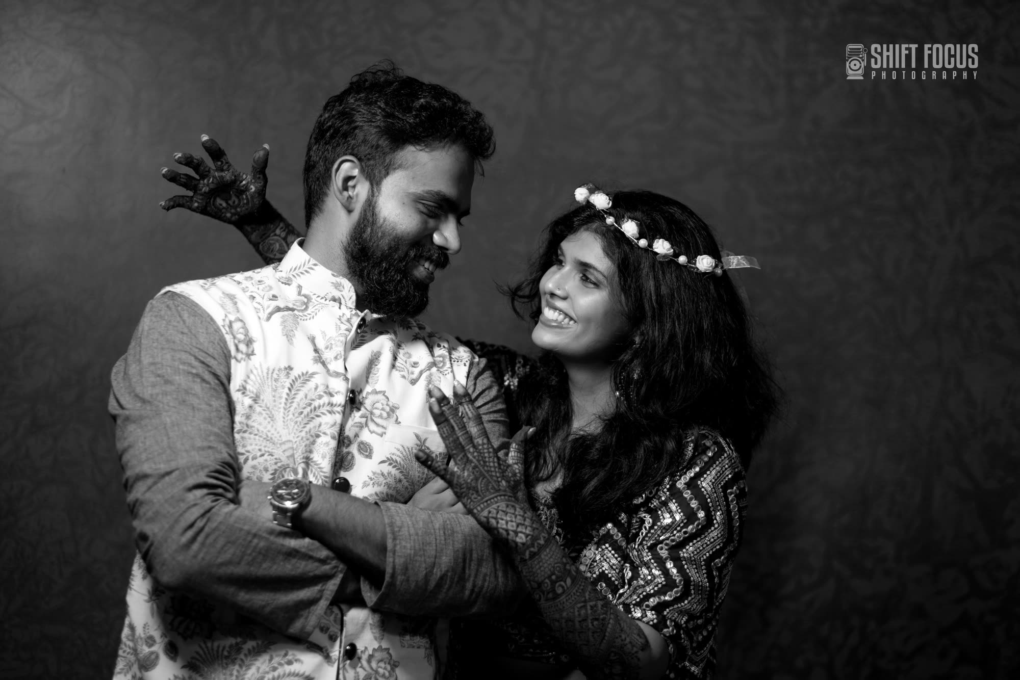 Couple laughing together at their mehndi shoot, in black and white