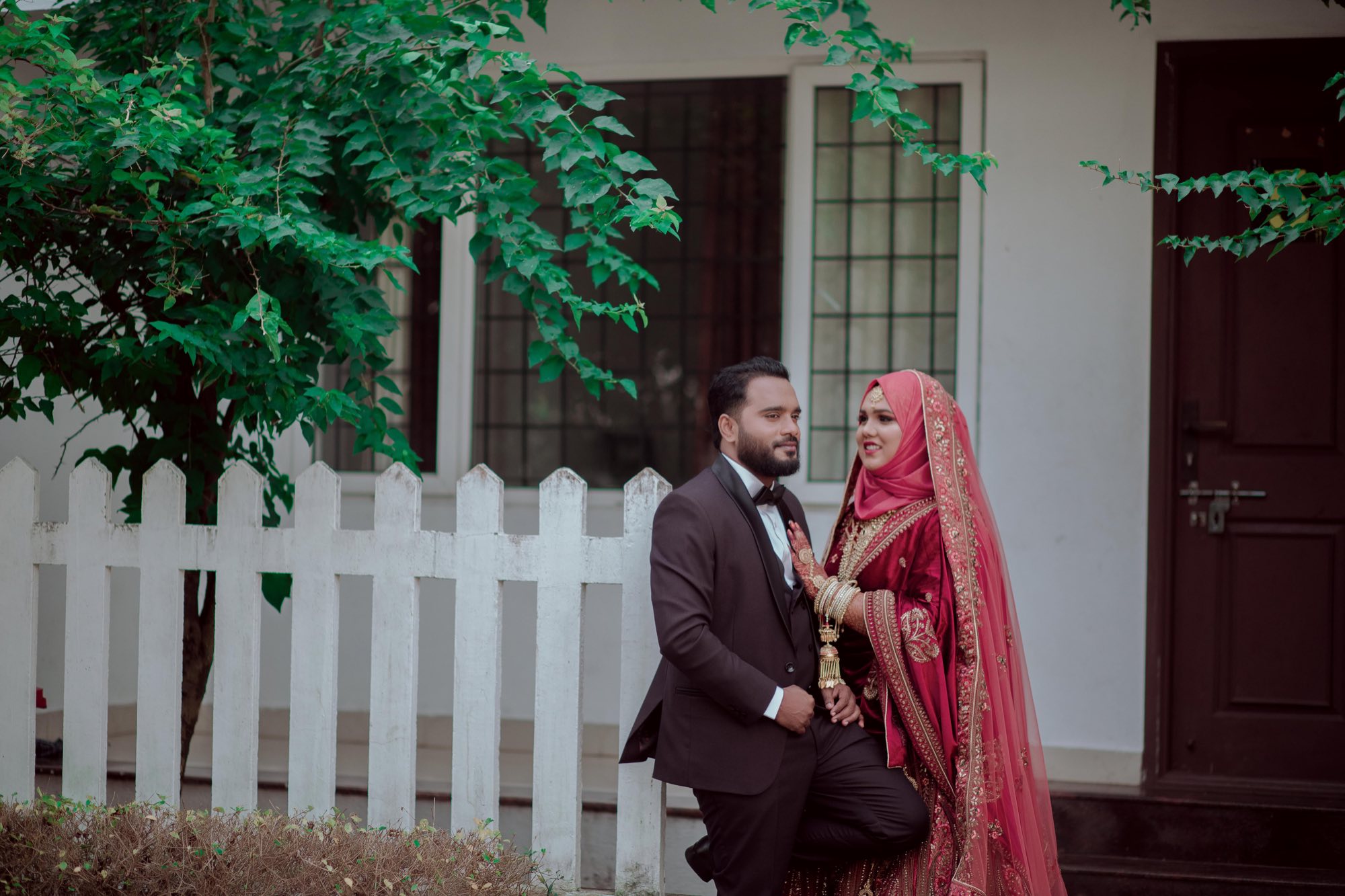 Couple by a white picket fence