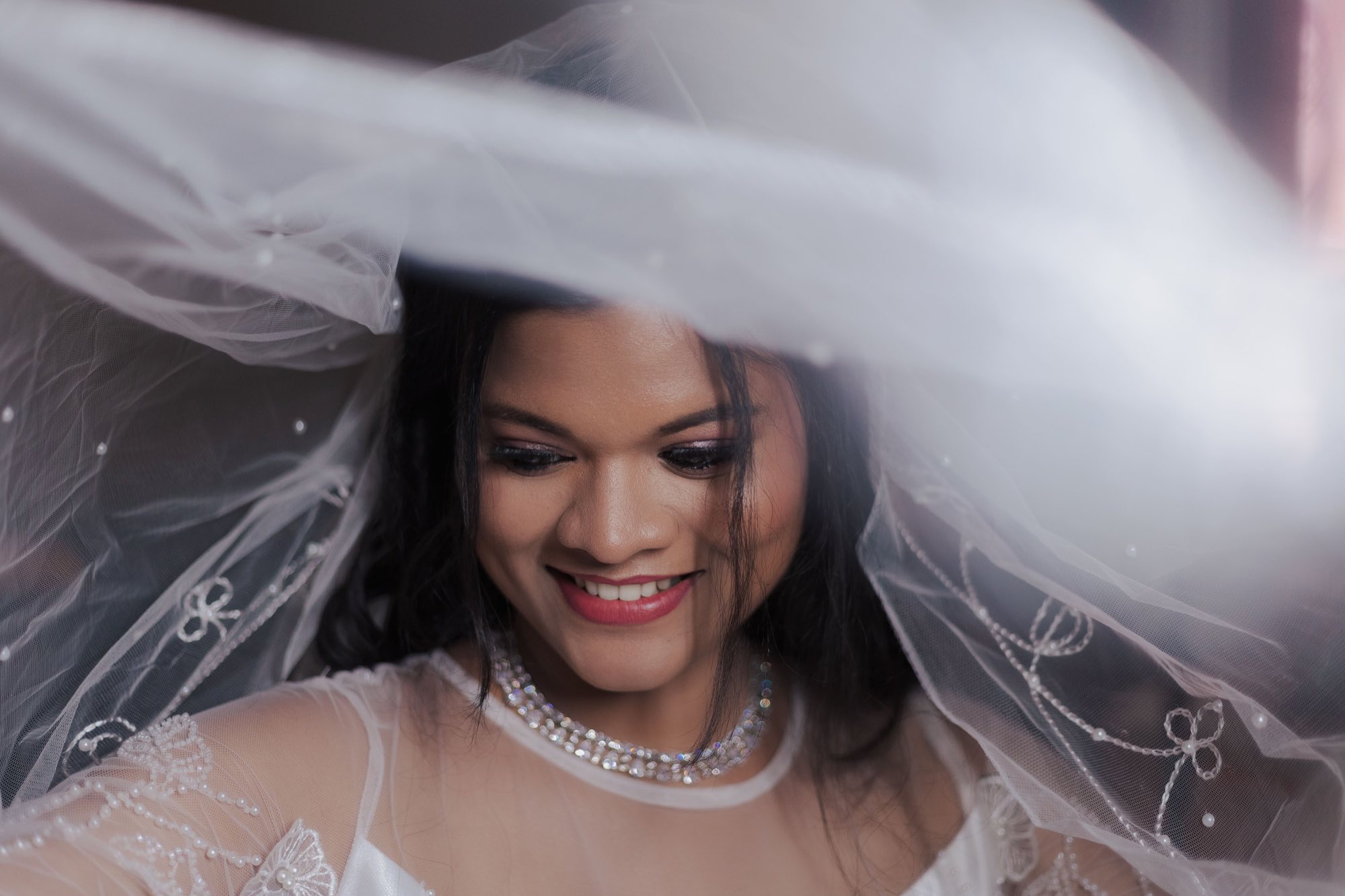 Bride laughing in her white veil