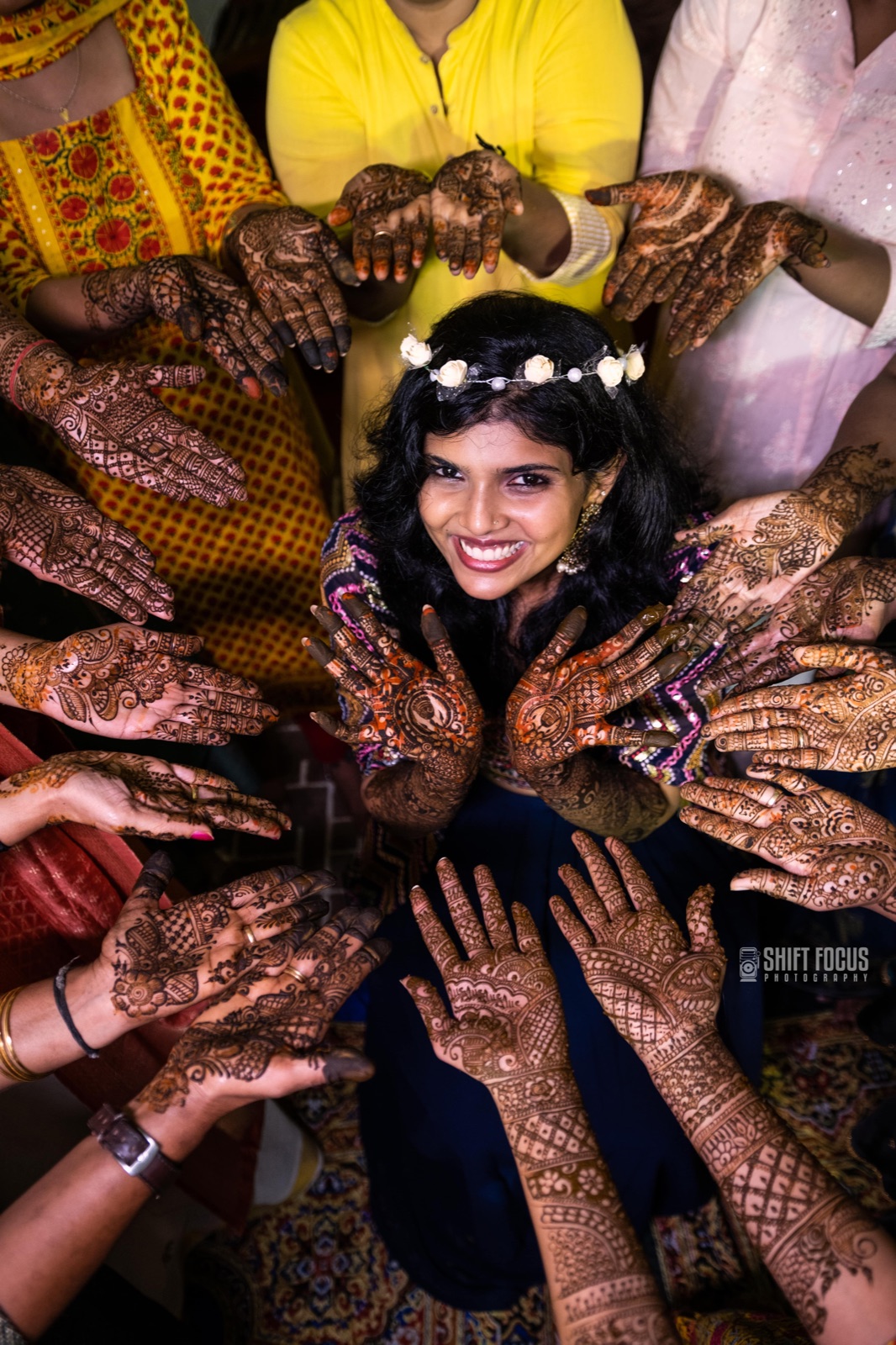 Bride encircled by mehndi-decorated hands