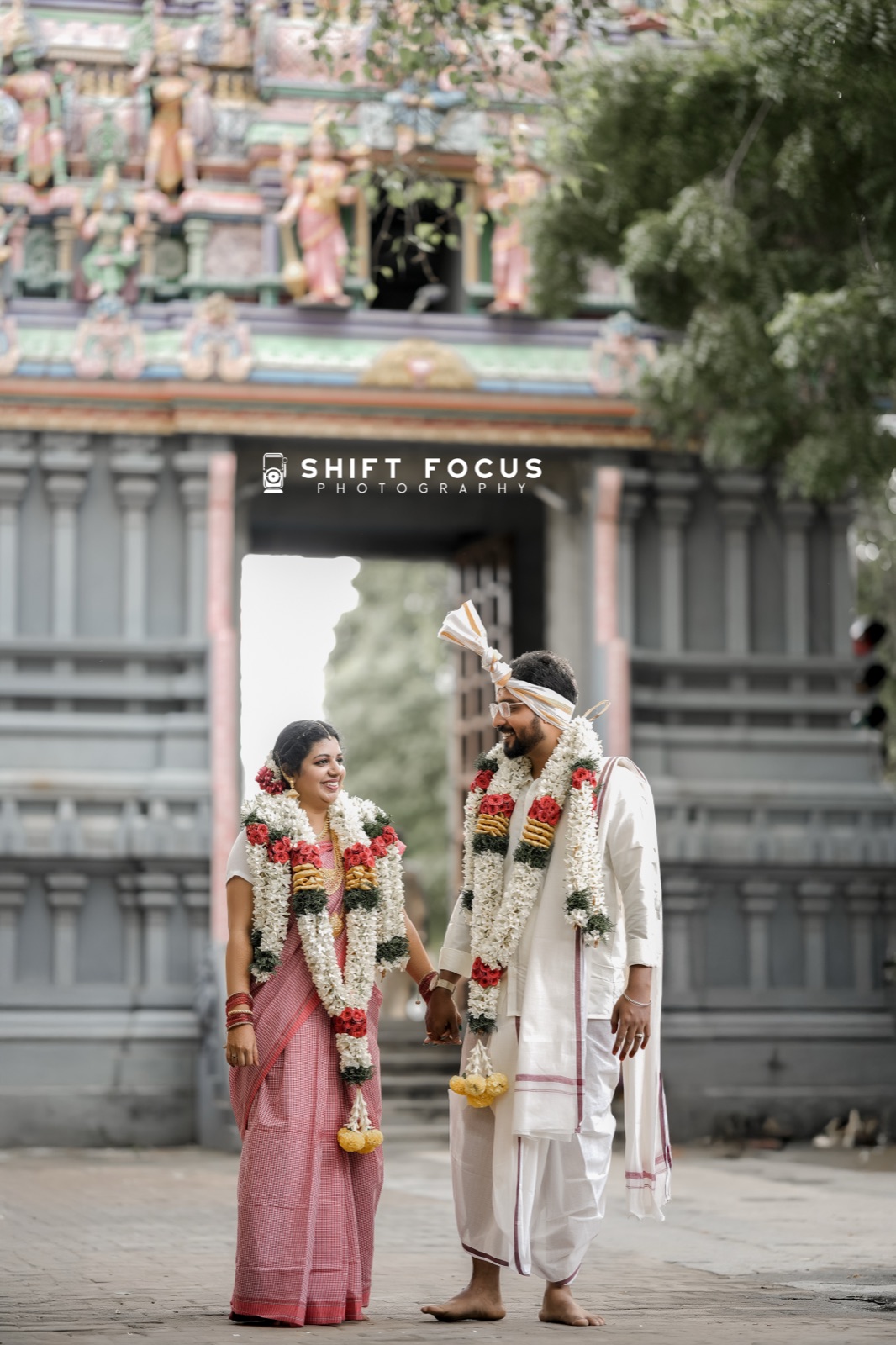 Garlanded couple before the temple gopuram