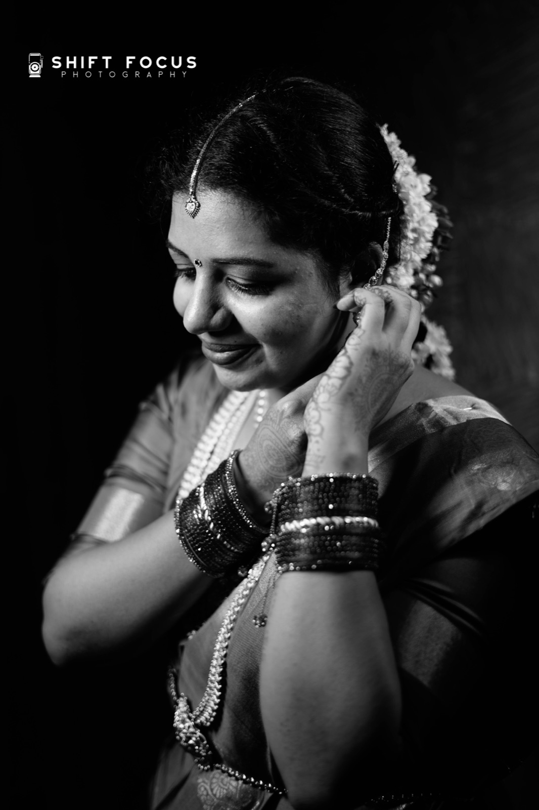 Bride pinning jasmine, in black and white