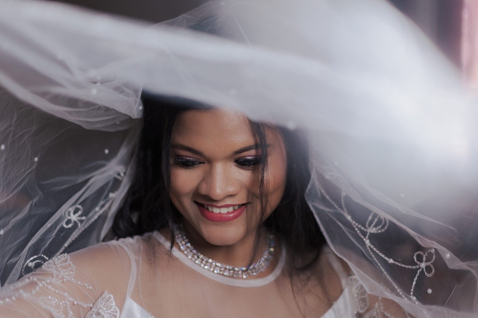 Bride smiling beneath her veil